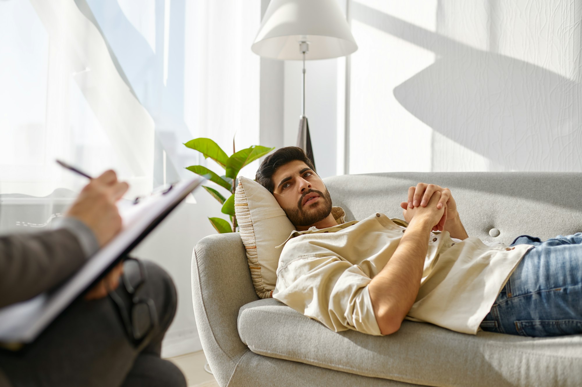 Pensive depressed man frowning looking at therapist